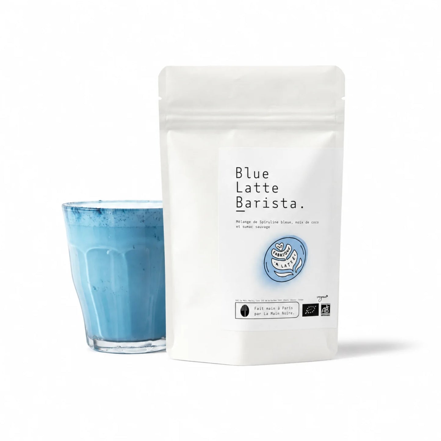 Blue Latte Barista – niebieskie latte ze spiruliną w opakowaniu oraz szklanka niebieskiego napoju na białym tle