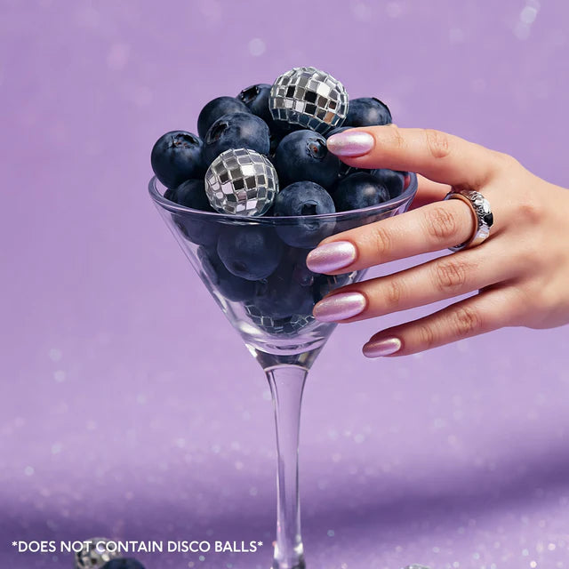 borówki w kieliszku trzymanym w dłoni – estetyczna kompozycja na fioletowym tle, inspiracja smak blueberry matcha, styl premium