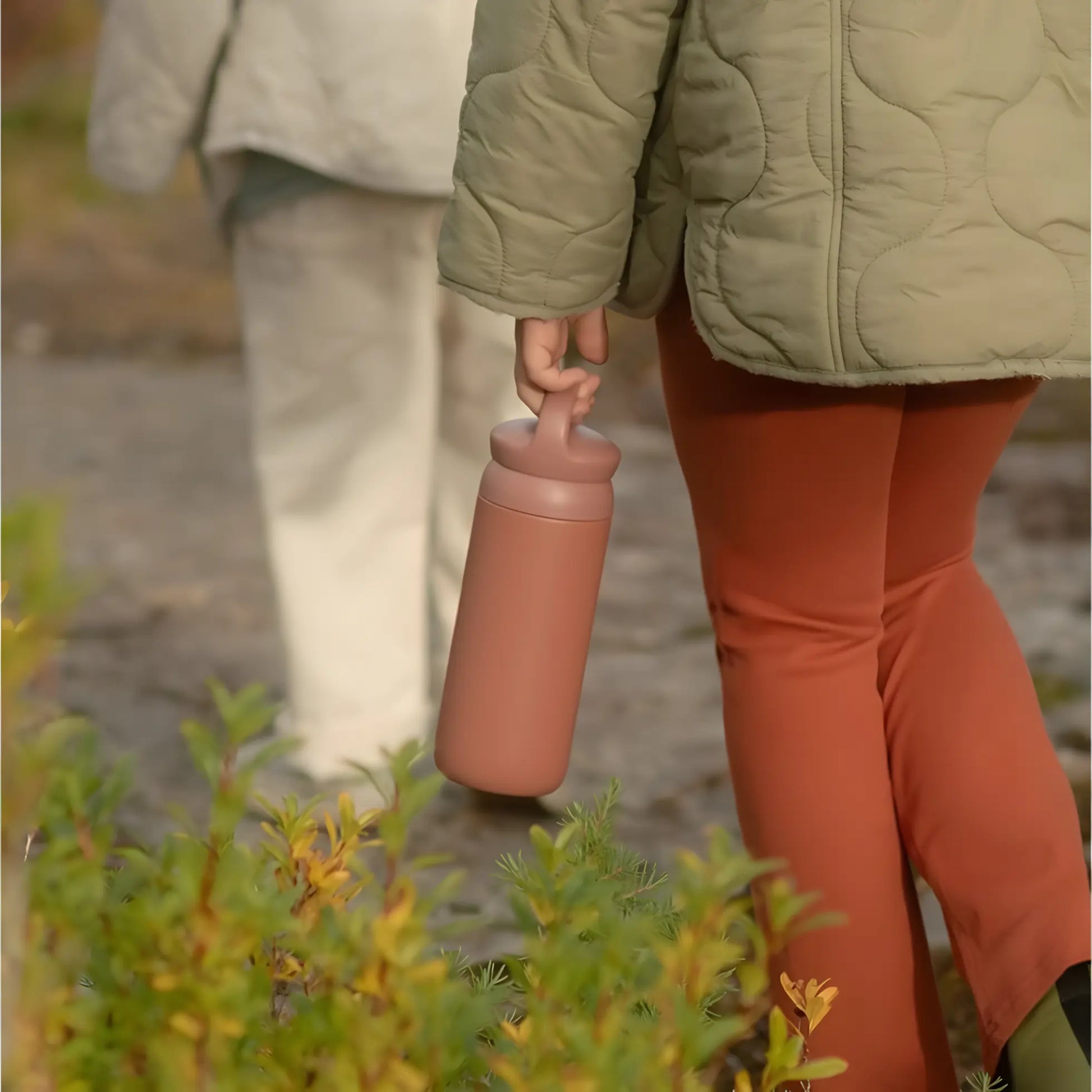 Butelka termiczna Kinto Day Off Tumbler 500 ml w kolorze pink trzymana w dłoni podczas spaceru – zdjęcie lifestyle