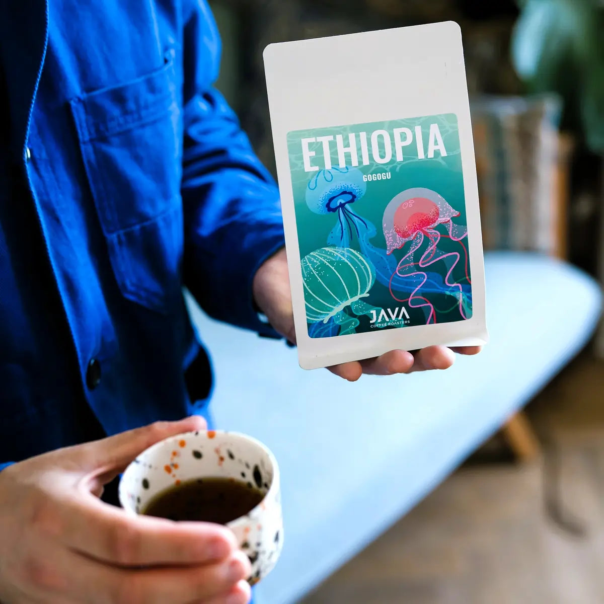 Degustacja kawy Ethiopia Gogogu od JAVA Coffee Roasters – filiżanka kawy i opakowanie produktu w dłoni