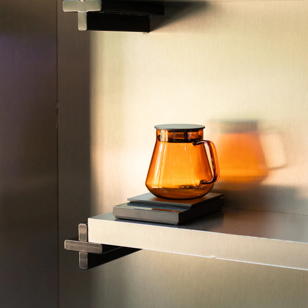 Hario Colors Tea & Coffee Server – bursztynowy szklany serwer do kawy i herbaty na metalowej półce, nowoczesne lifestyle zdjęcie