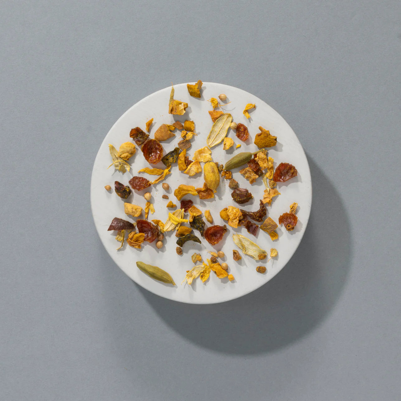 Sypana herbata Suki Spiced Pumpkin Pie widziana z góry – mieszanka suszonych owoców, przypraw i ziół na jasnym talerzyku, na szarym tle.
Sypana herbata Suki Spiced Pumpkin Pie widziana z góry – mieszanka suszonych owoców, przypraw i ziół na jasnym talerzyku, na szarym tle.