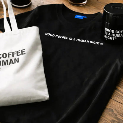 Zestaw brandowy JAVA Coffee Roasters – koszulka, torba i puszka z hasłem Good Coffee Is a Human Right, lifestyle scena przy kawie
