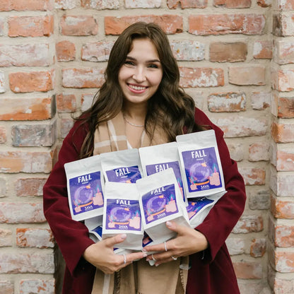 Jesienna kawa Fall Espresso od JAVA Coffee Roasters – kobieta trzyma kilka opakowań kawy specialty