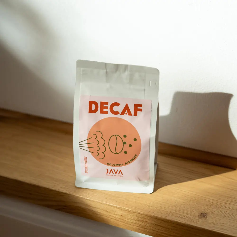 Kawa bezkofeinowa Java Coffee Roasters Decaf Colombia Asomuier 250g w opakowaniu na drewnianej półce w świetle słońca