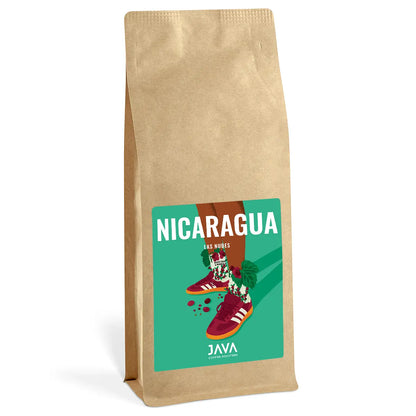 Opakowanie kawy JAVA Coffee Roasters – Nicaragua Las Nubes. Biała torebka z kolorową etykietą przedstawiającą ilustrację nóg w czerwonych sportowych butach i skarpetach ozdobionych motywem kawowych owoców i liści. Na etykiecie duży, biały napis 'NICARAGUA LAS NUBES' na zielonym tle.