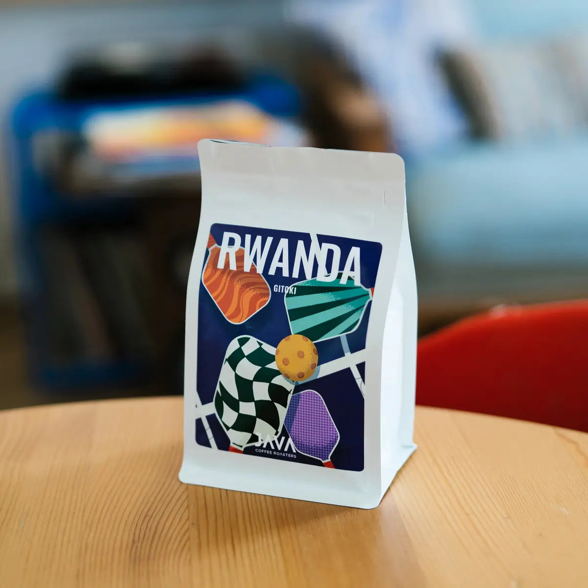 Kawa ziarnista specialty Rwanda Gitoki od JAVA Coffee Roasters w białym opakowaniu na drewnianym stole