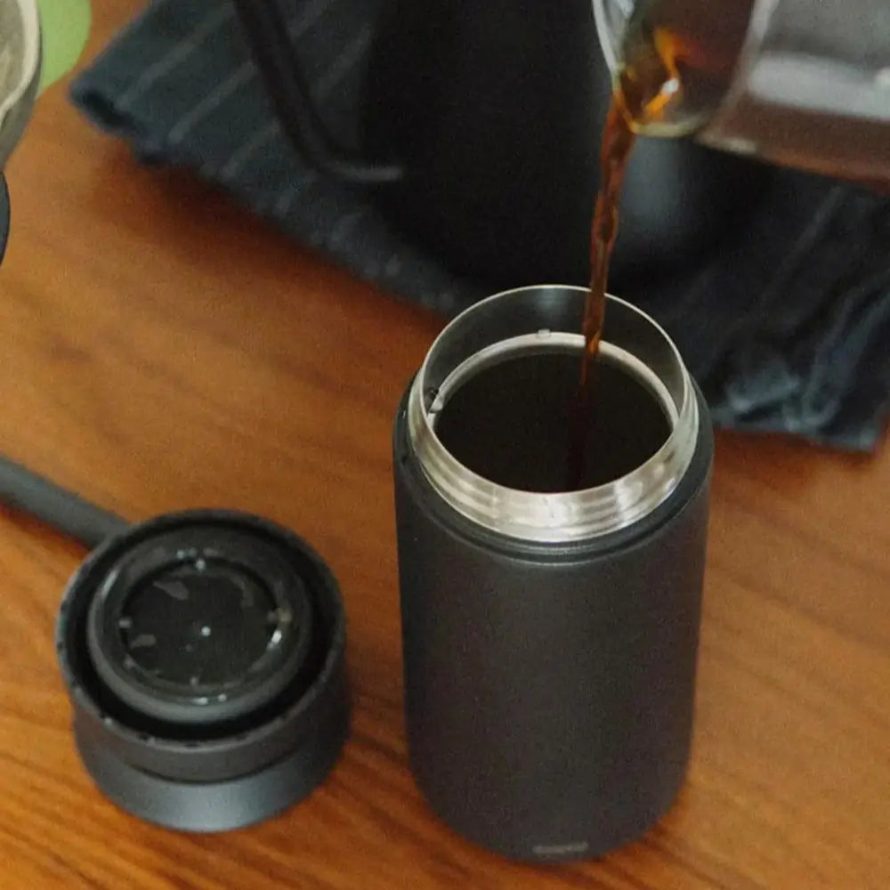 Wlewanie gorącej kawy do czarnego kubka termicznego Kinto Travel Tumbler 350 ml