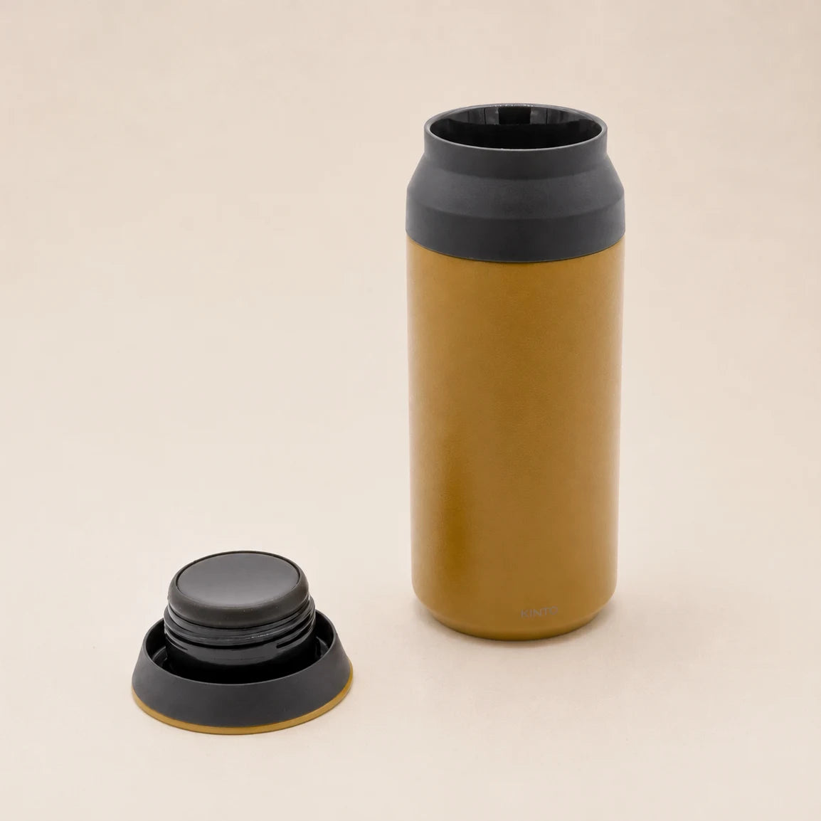Żółty kubek termiczny Kinto Travel Tumbler z odkręconą nakrętką