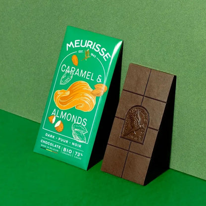tabliczka czekolady Meurisse Caramel & Almonds 73% obok zielonego opakowania na zielonym tle