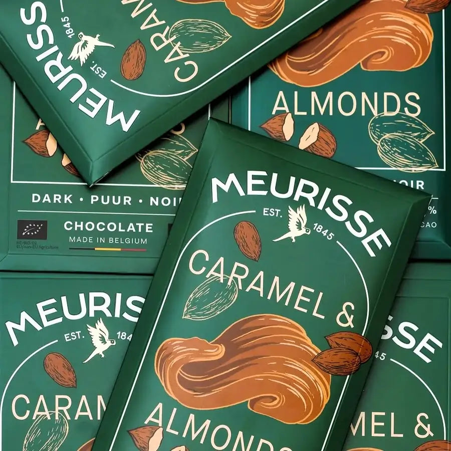 kilka tabliczek czekolady Meurisse Caramel & Almonds ułożonych na sobie, w zielonych opakowaniach z ilustracjami karmelu i migdałów