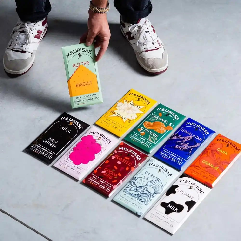 zestaw dziesięciu tabliczek czekolady Meurisse w kolorowych opakowaniach, ułożonych na podłodze