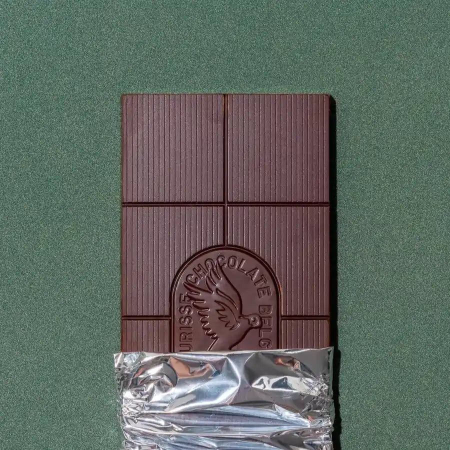 tabliczka ciemnej czekolady Meurisse częściowo odwinięta z folii na zielonym tle