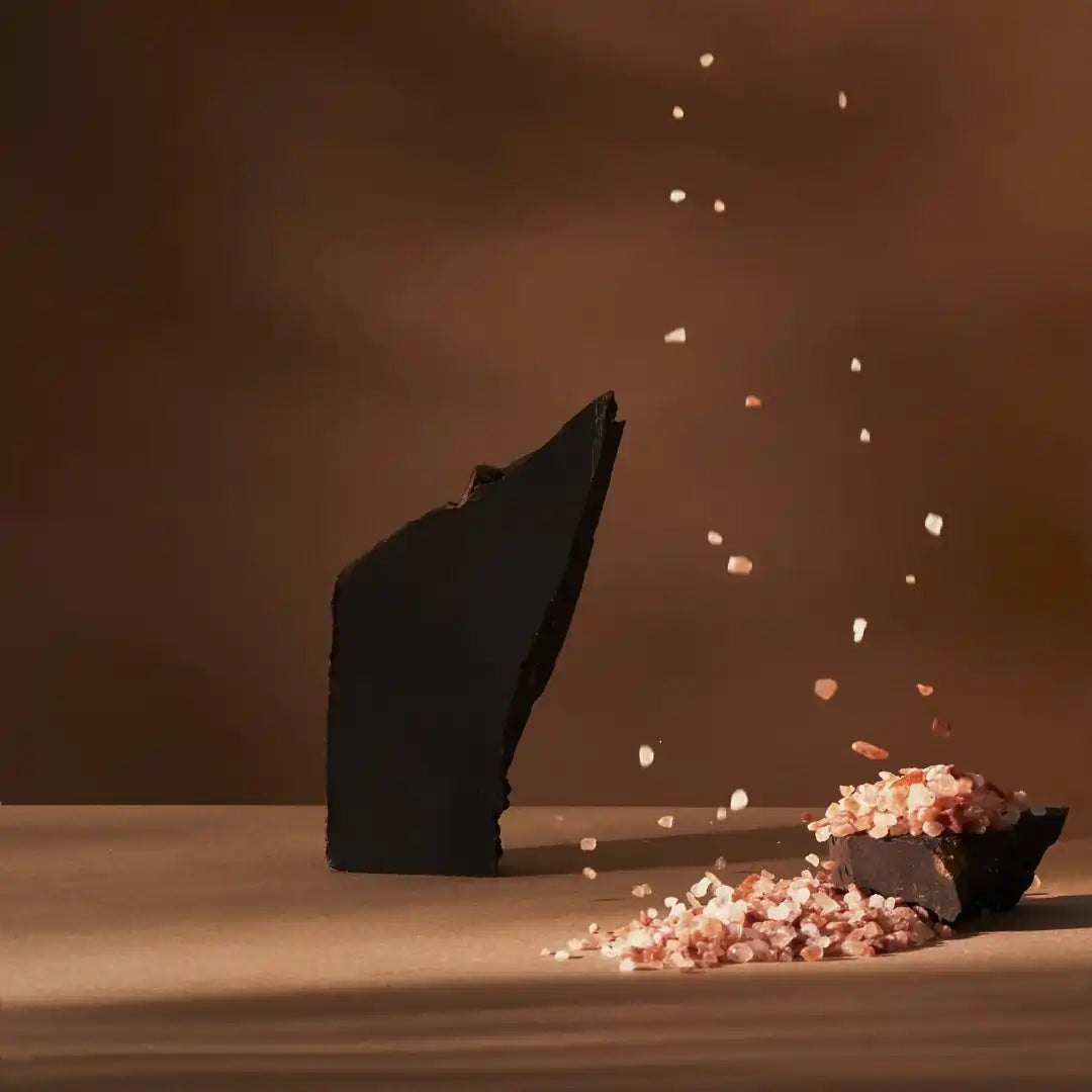 kawałek ciemnej czekolady Meurisse z solą himalajską na brązowym tle, z rozsypującymi się kryształkami soli