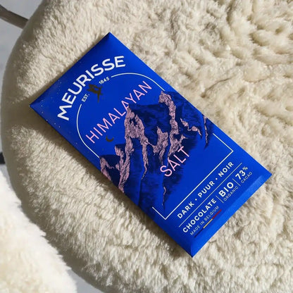 tabliczka czekolady Meurisse Himalayan Salt 73% kakao leżąca na kremowym, puszystym kocu