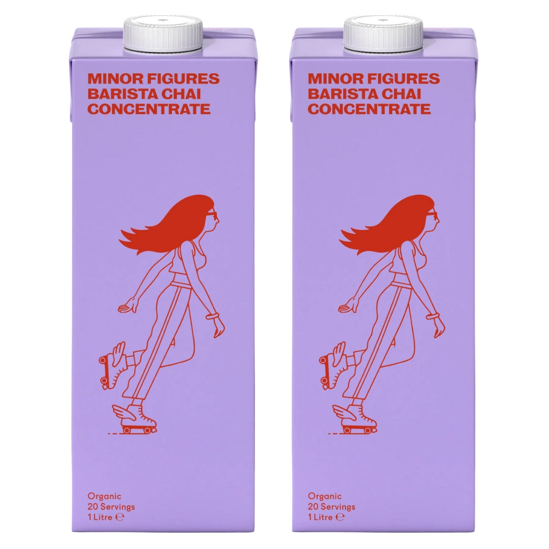 Dwa kartony koncentratu herbaty chai Minor Figures Barista Chai Concentrate 1L w fioletowych opakowaniach z czerwonym nadrukiem postaci na wrotkach.