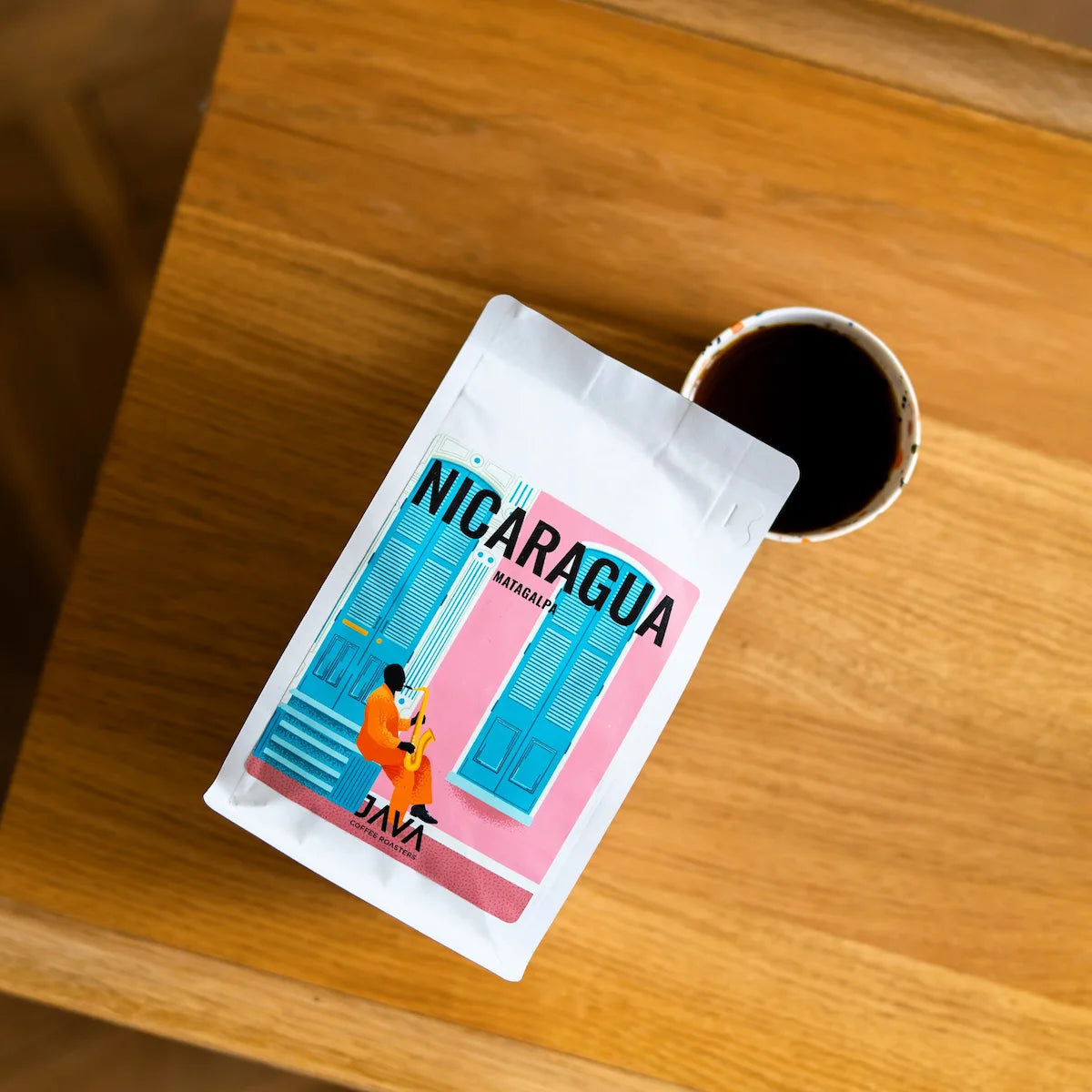 Kawa specialty Nicaragua Matagalpa JAVA Coffee Roasters z filiżanką czarnej kawy – widok z góry