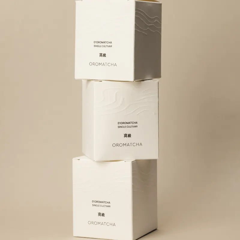 Oromatcha Single Cultivar – opakowania premium matcha, minimalistyczny packshot na beżowym tle