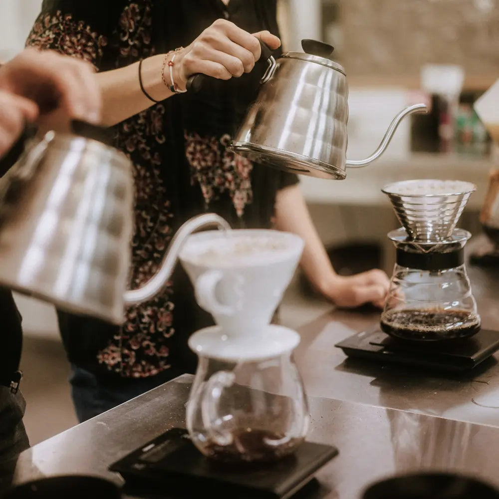 Osoba parzy kawę metodą pour-over z użyciem drippera i kettle’a podczas warsztatów kawowych JAVA Coffee Roasters.