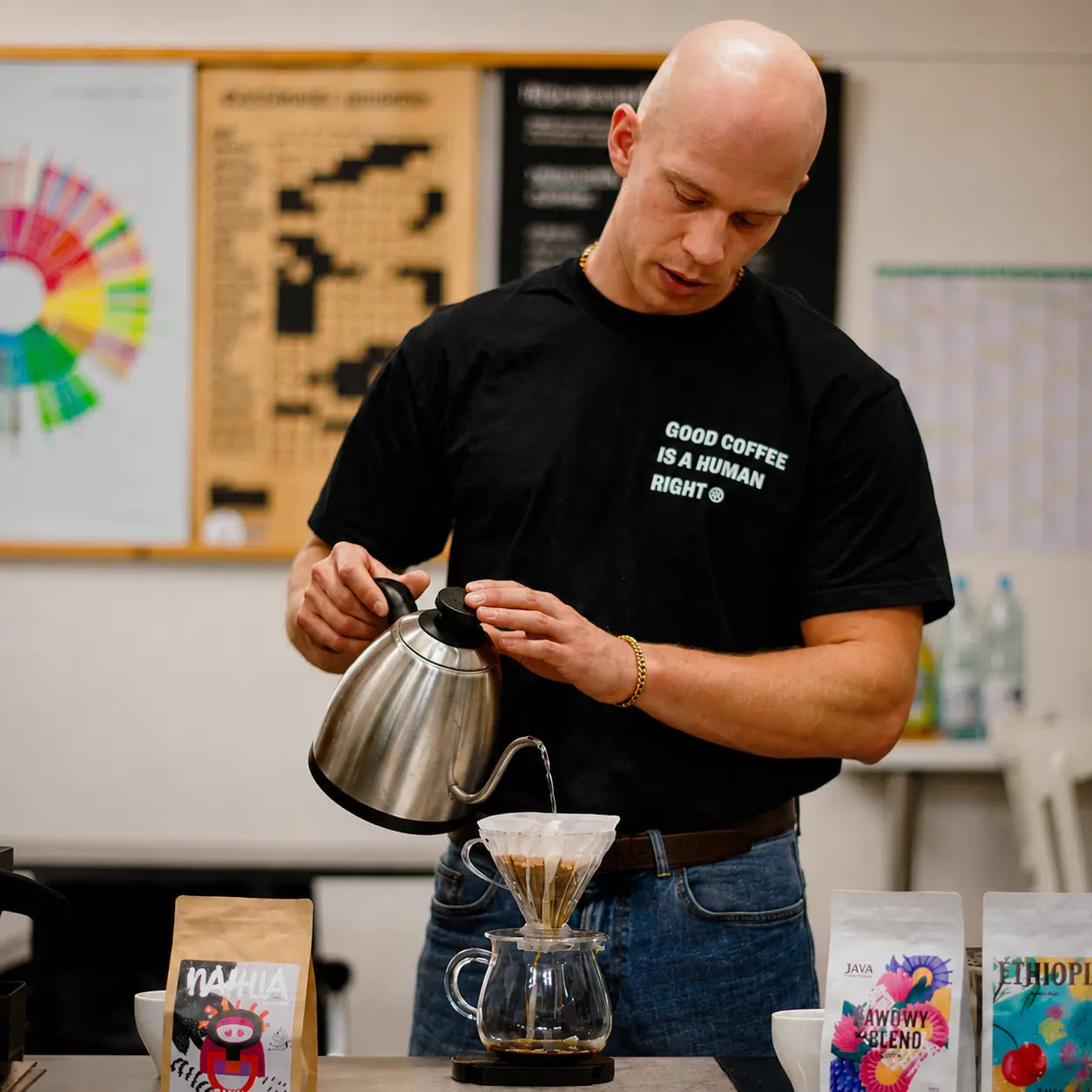 Instruktor przygotowuje kawę metodą V60 podczas szkolenia Home Barista. Praktyczna nauka parzenia kawy przelewowej z wykorzystaniem drippera i czajnika z wylewką typu goose neck.