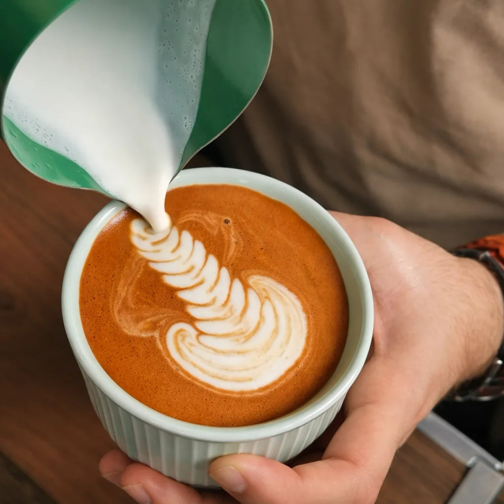 Zbliżenie na rooibos latte z mleczną pianką i latte artem, nalewanie mleka do napoju roślinnego na bazie rooibosa