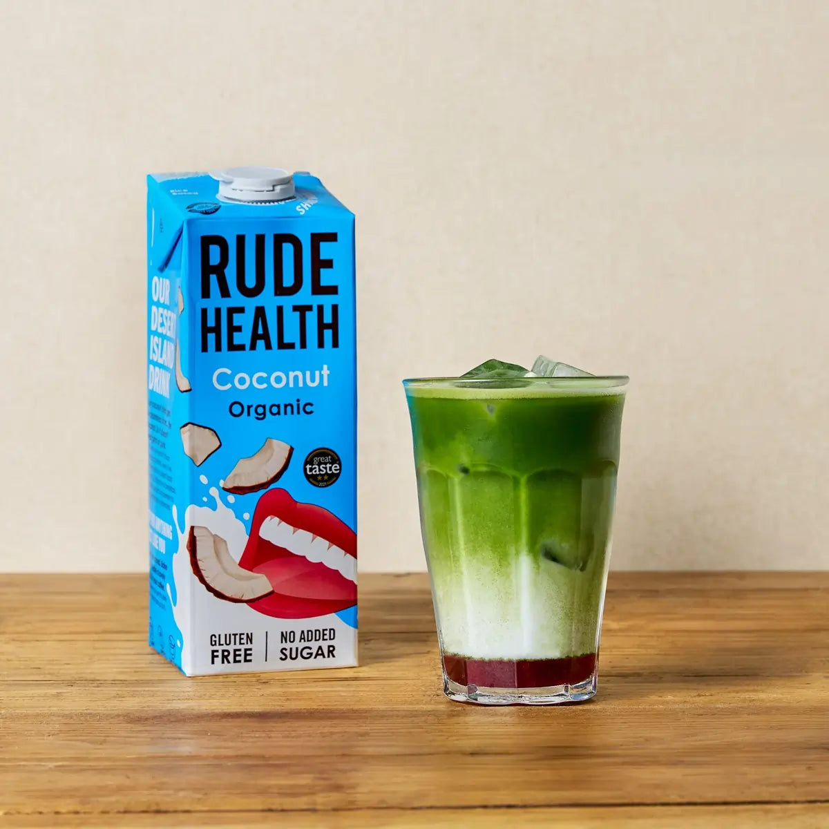 Rude Health Coconut Organic – napój kokosowy idealny do matchy, z widoczną warstwą matcha latte z lodem.
