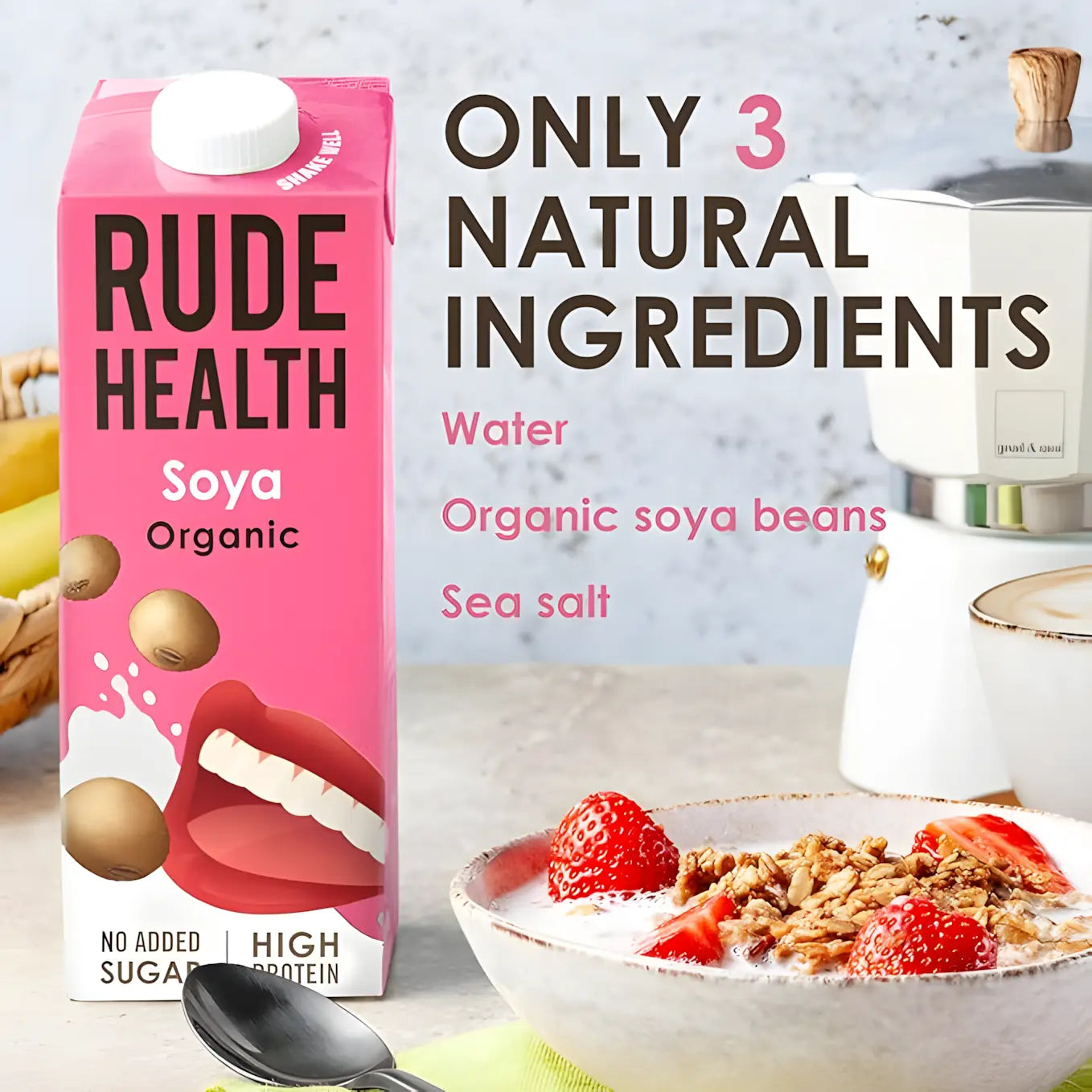 Napój sojowy Rude Health Soya Organic w różowym kartonie obok miski z granolą i truskawkami, z napisem „Only 3 natural ingredients: water, organic soya beans, sea salt