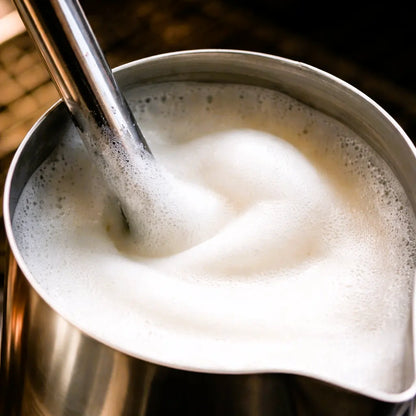 Spienione mleko z mikrospieną w dzbanku baristycznym, przygotowanie mleka do kawy espresso i cappuccino
