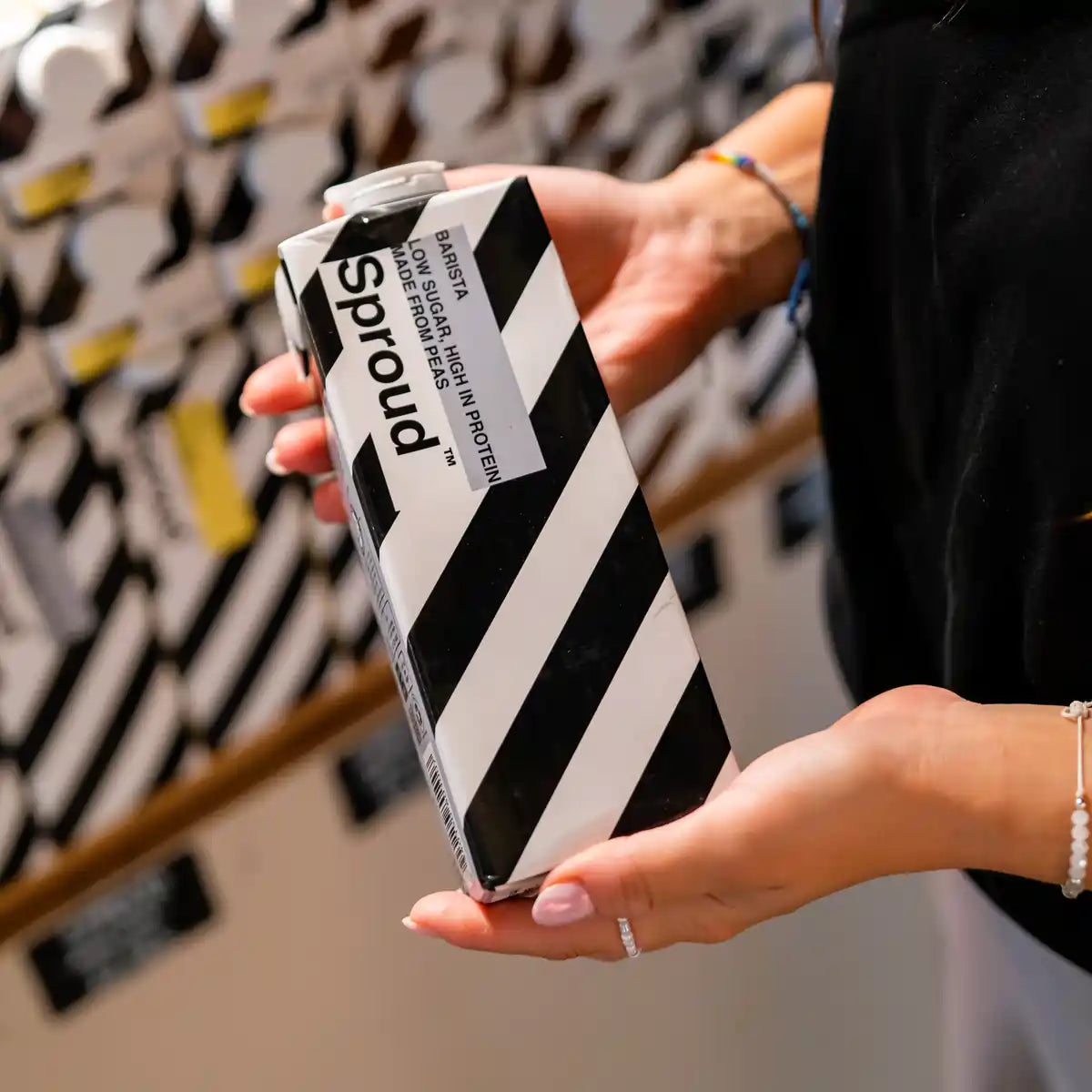 Karton napoju roślinnego Sproud Barista 1L trzymany w dłoniach – wegański napój z grochu, idealny do kaw mlecznych, źródło białka i niska zawartość cukru.