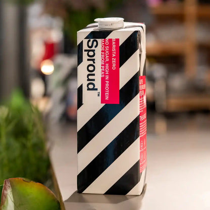 Karton napoju roślinnego Sproud Barista Zero 1L ustawiony na stole – wegański napój z grochu bez cukru, wysokobiałkowy, stworzony do kaw mlecznych.