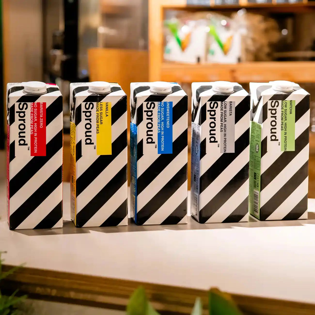 Pięć kartonów napojów roślinnych Sproud w różnych smakach – Barista Zero, Vanilla, Unsweetened, Barista oraz Matcha. Wegańskie napoje z grochu, bogate w białko.