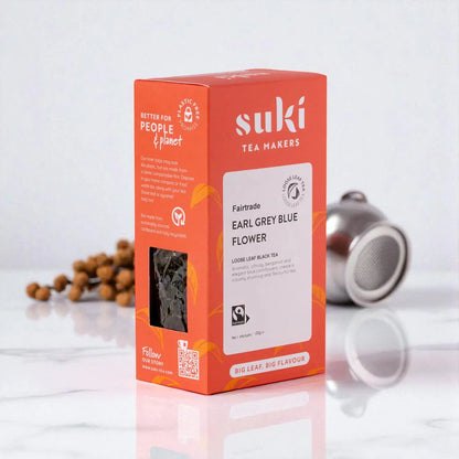 Suki Tea Earl Grey Blue Flower – czarna herbata liściasta Fairtrade 100g w opakowaniu na stole z zaparzaczem