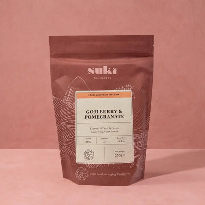 Packshot herbaty owocowej Suki Tea Goji Berry & Pomegranate 250 g – opakowanie herbaty liściastej na różowym tle, zdjęcie produktowe