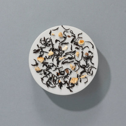 czarna herbata liściasta Suki Tea Mince Pie z widocznymi kawałkami imbiru i przypraw na szarym tle