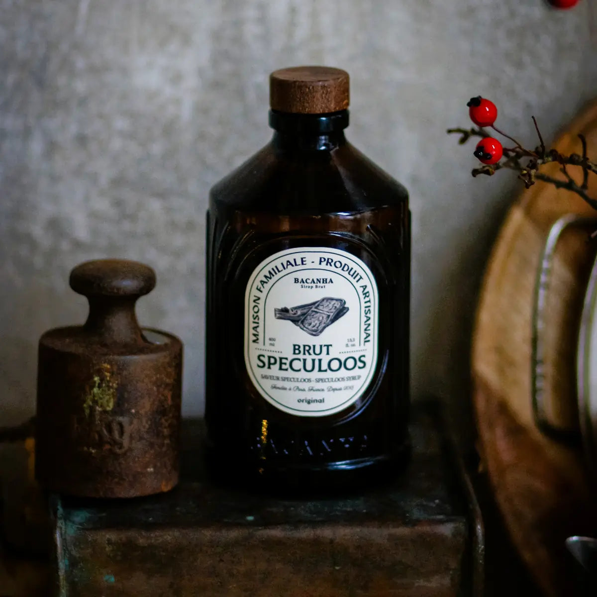 Syrop Bacanha Brut Speculoos w brązowej butelce ustawiony w klimatycznej, rustykalnej aranżacji