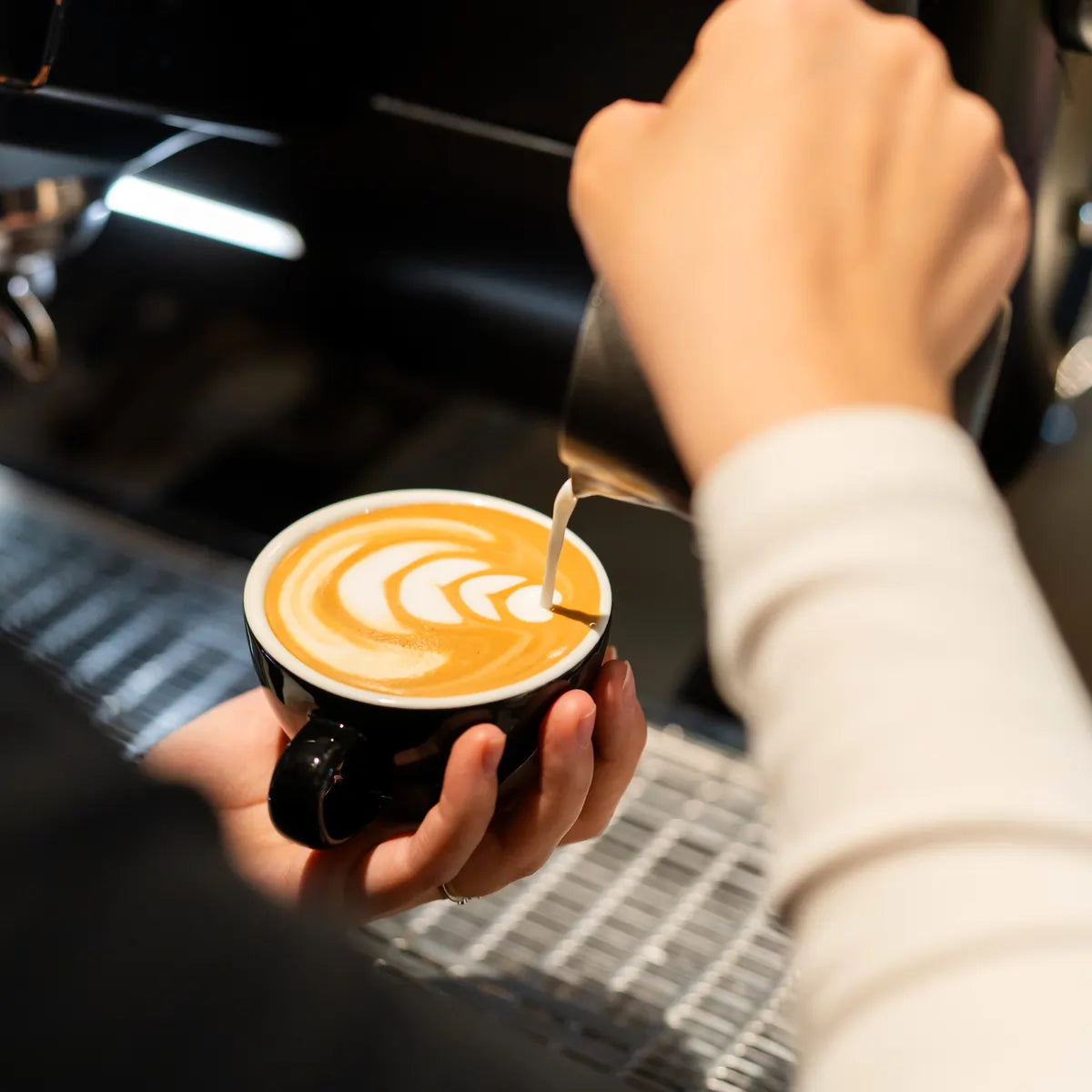 Nauka latte art – nalewanie mleka do kawy podczas szkolenia baristycznego JAVA Coffee