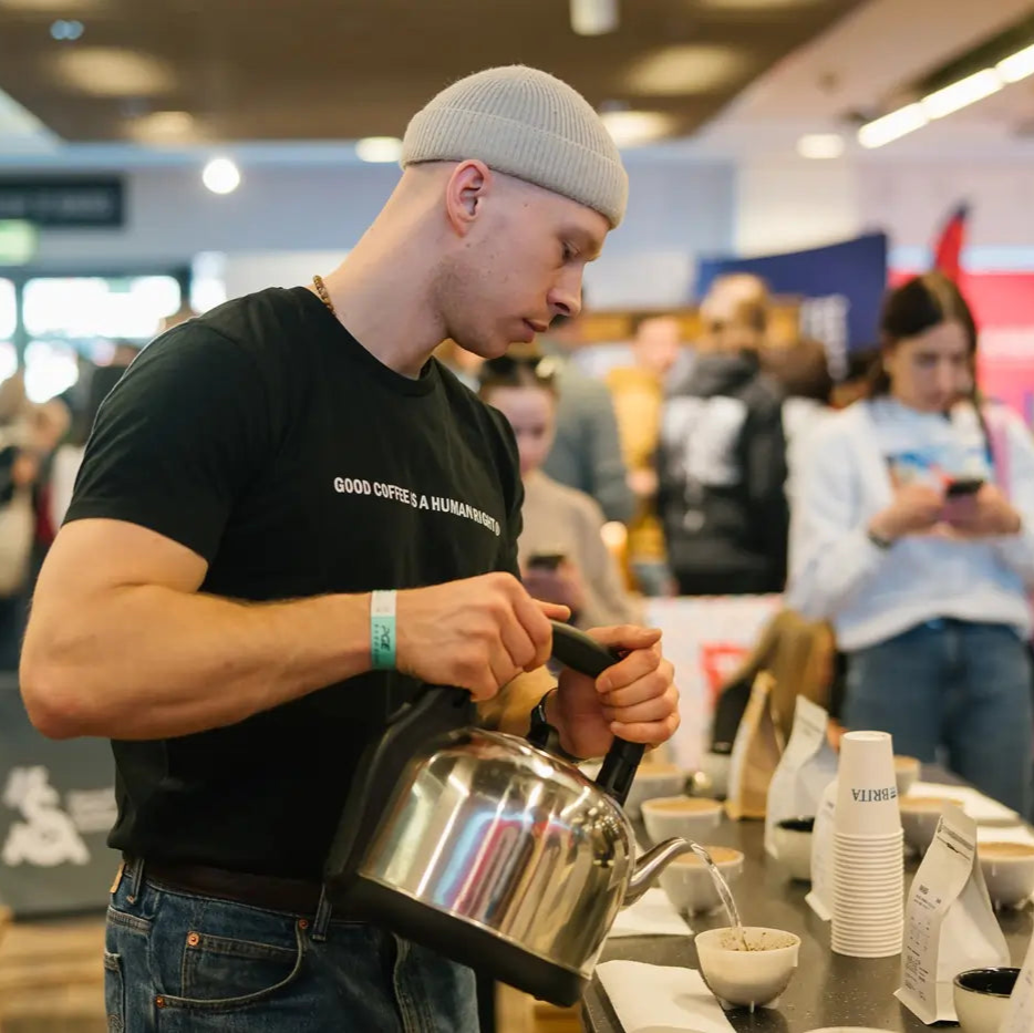 Michał Żmuda, Trener JAVA University, przygotowuje kawę metodą przelewową podczas festiwalu kawy Warsaw Coffee festiwal 2025.