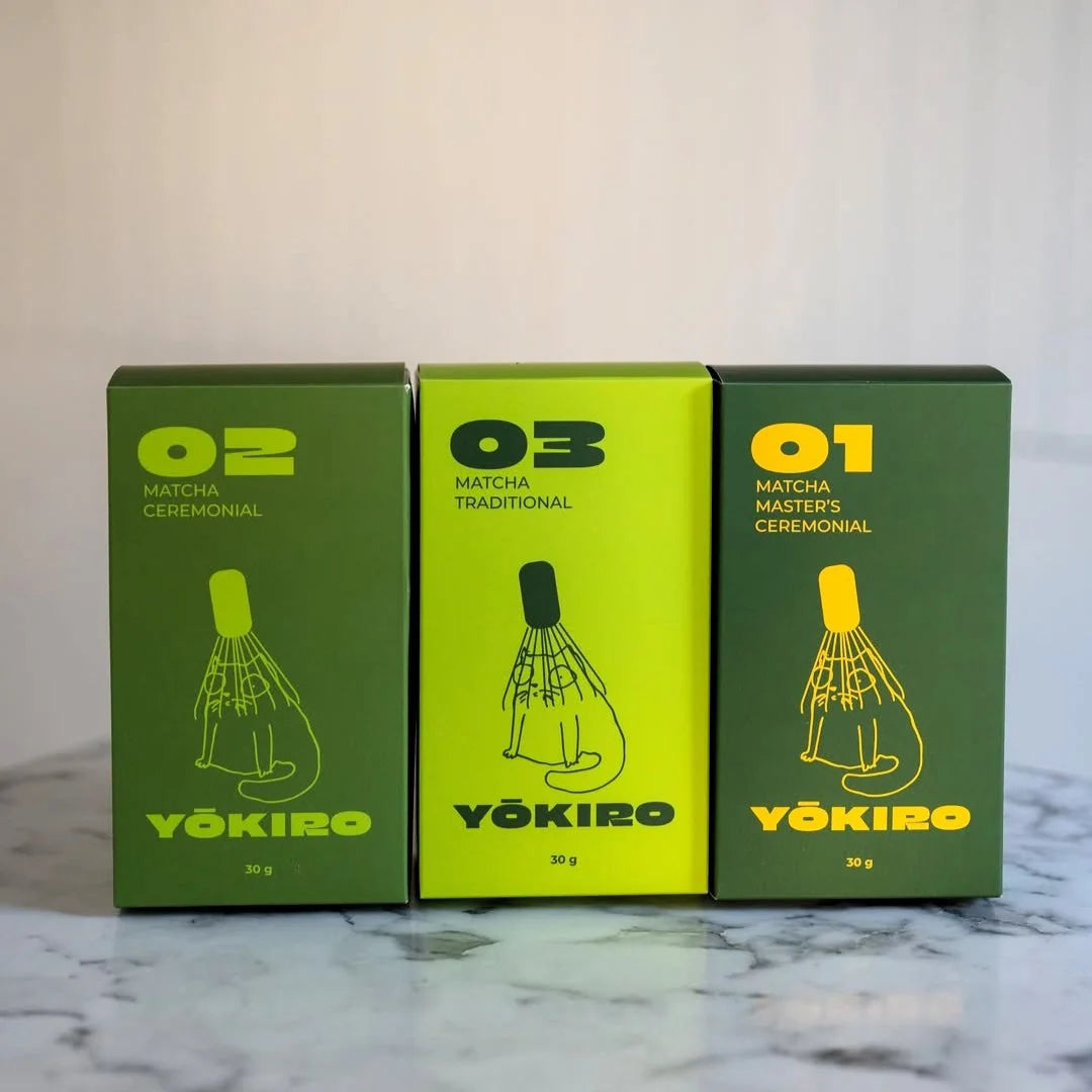 Trzy opakowania matchy Yōkiro ustawione obok siebie – Matcha Ceremonial, Matcha Traditional i Matcha Master’s Ceremonial na marmurowym blacie