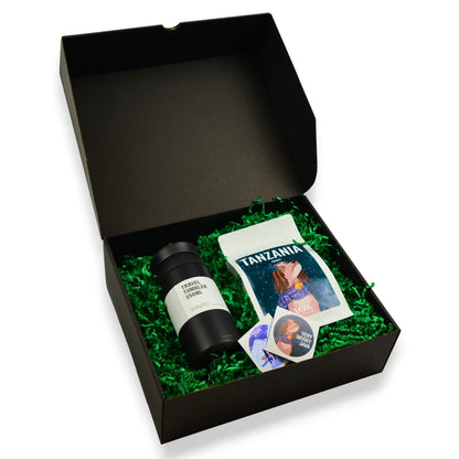 Świąteczny zestaw prezentowy JAVA Coffee w czarnym pudełku, zawierający kawę Tanzania Itumpi oraz czarny kubek termiczny KINTO 350 ml na zielonym wypełnieniu.