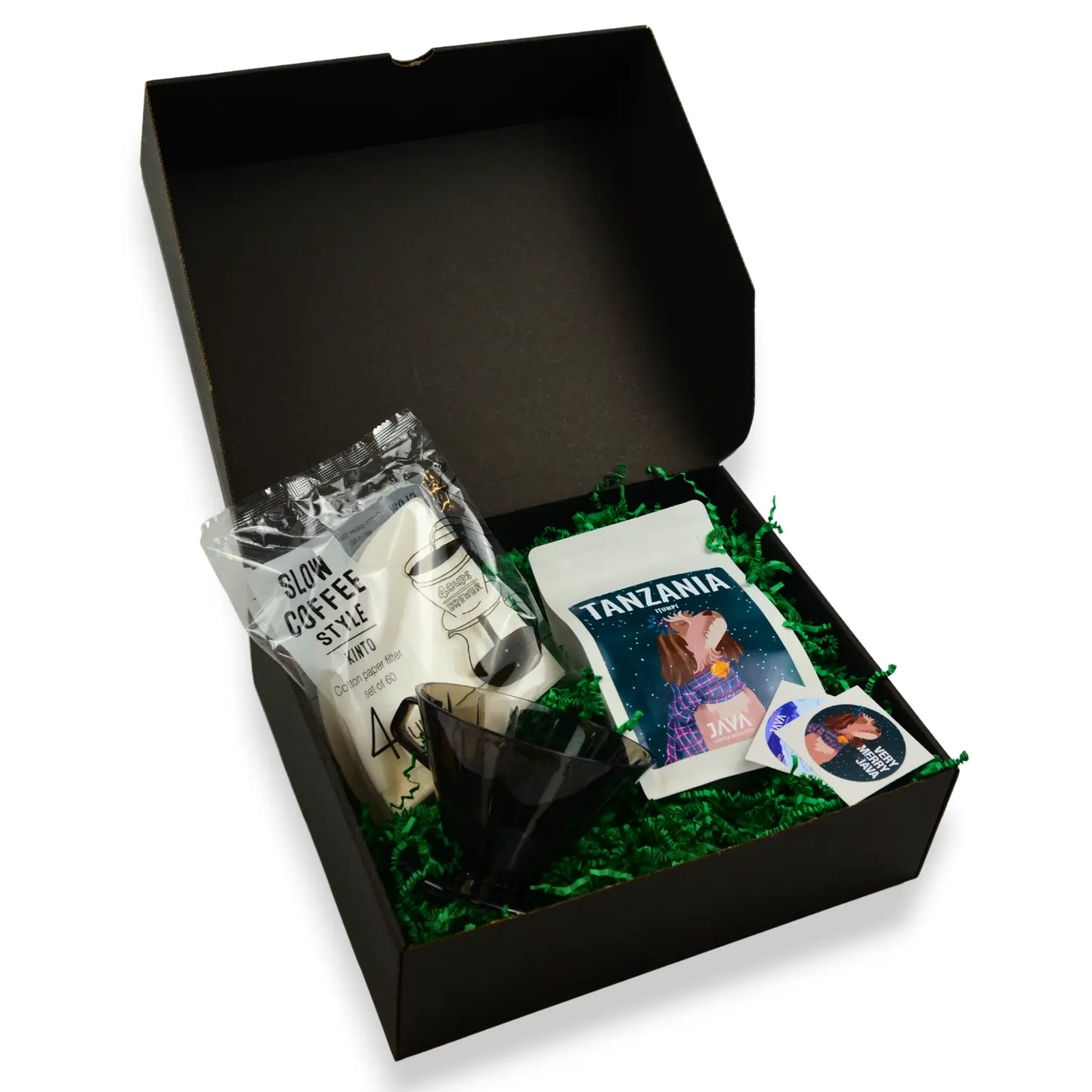 Zestaw świąteczny JAVA Coffee: kawa Tanzania Itumpi, dripper Kinto i filtry w czarnym pudełku prezentowym na zielonym wypełniaczu.